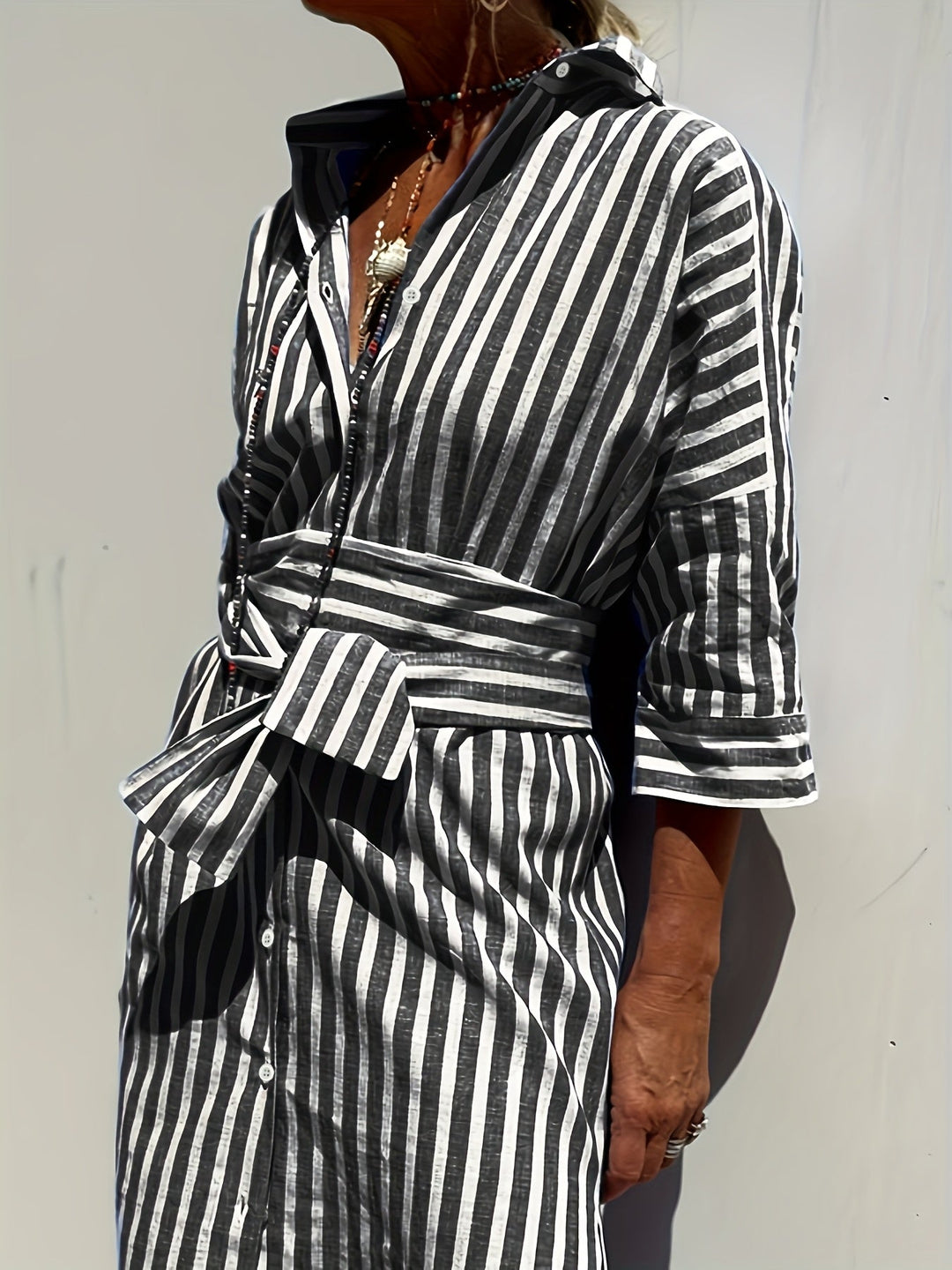 Fashionable striped shirt dress for women, featuring a belt & front buttons.
