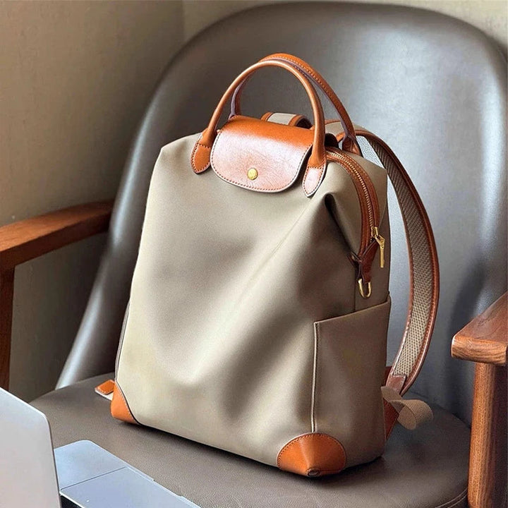 Women's structured backpack with leather trim, spacious for everyday travel. Elegant and practical ladies bag.