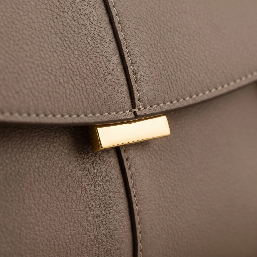 Elegant ladies structured handbag with a top handle, refined accessory for a minimalist fashion look.