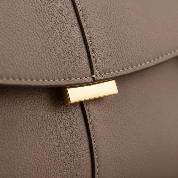 Elegant ladies structured handbag with a top handle, refined accessory for a minimalist fashion look.