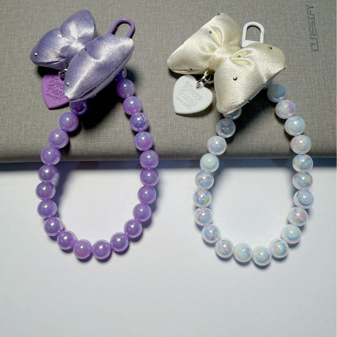 Close-up of elegant bow accent on a stylish beaded women's keychain, a charming handbag accessory.