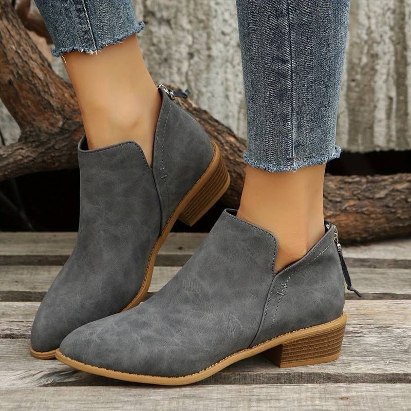 Fashionable women's ankle boots with a low heel, pointed toe, & convenient zipper closure for comfort and style.