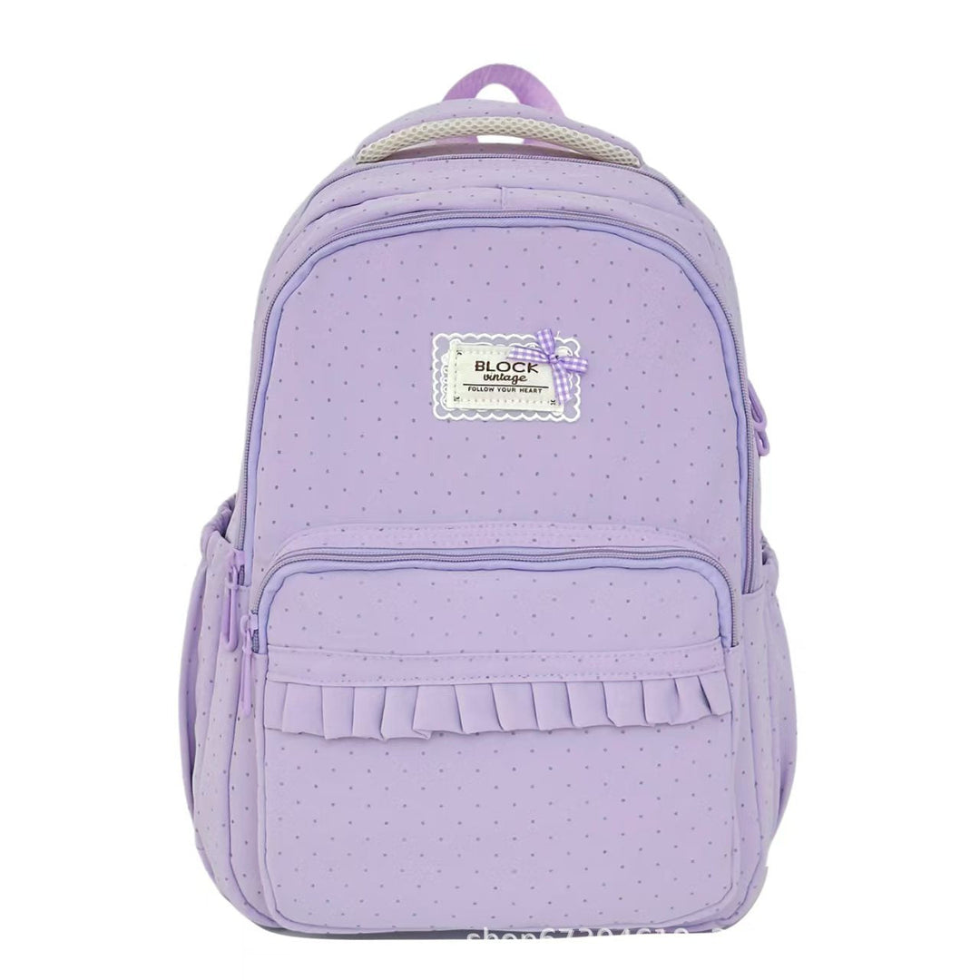 Black polka dot ruffled women's backpack, a chic and durable choice for school and casual wear.