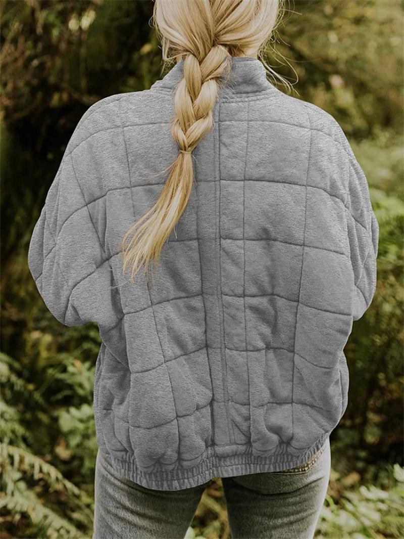 Lightweight women's quilted jacket with a sturdy zipper, offering comfort and style for transitional weather.