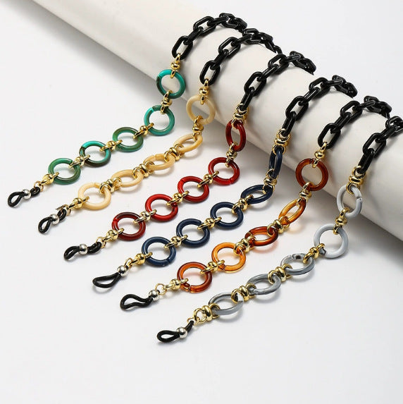 Women's stylish black sunglasses with unique gold chain pendant. UV protected fashion eyewear.