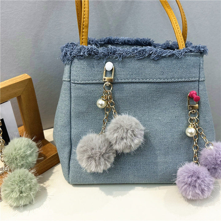 Stylish women's denim shoulder tote with distinctive frayed details, a perfect casual bag.