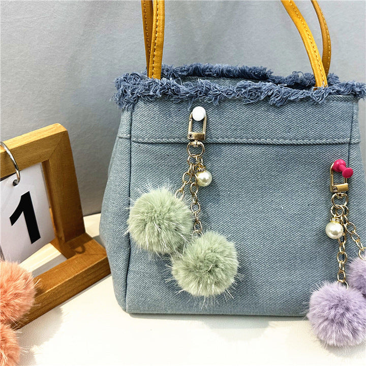 Chic women's denim tote bag, a casual accessory with trendy frayed edges and spacious design.