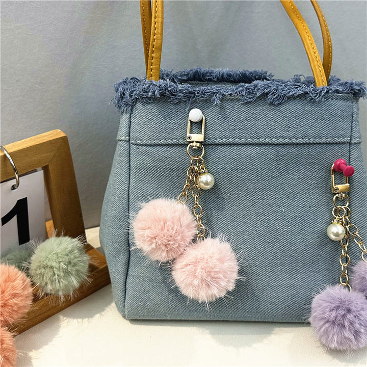 Versatile women's denim shoulder bag, featuring frayed edges and a fashionable, casual style.