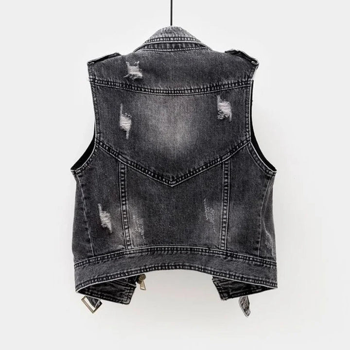 Trendy women's distressed denim vest, featuring a moto design and comfortable sleeveless fit.