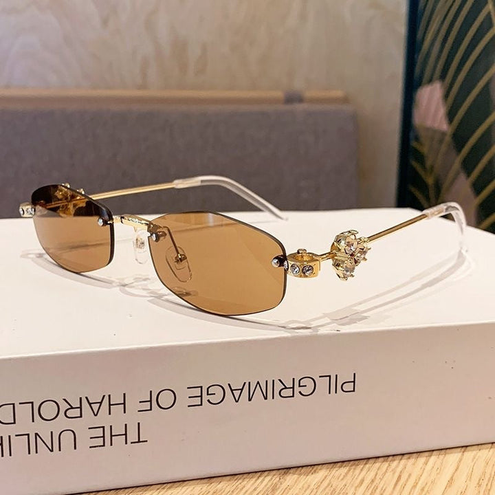 Luxury women's eyewear: geometric sunglasses with dazzling golden details for summer style.