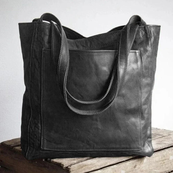 Versatile women's brown PU leather shoulder bag with a convenient front pocket and secure magnetic snap.