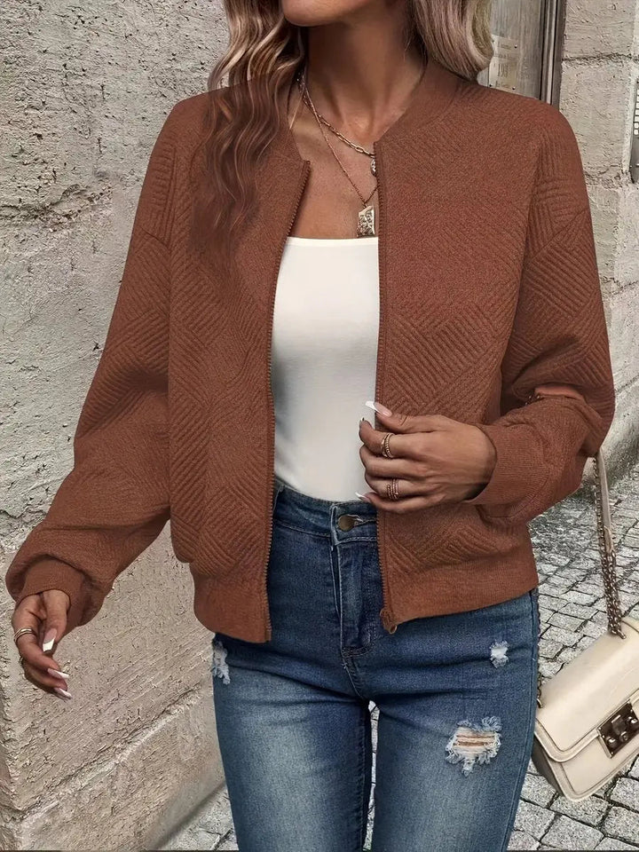Front view of women's quilted bomber jacket. Cropped, zip-up design, versatile spring layering piece.