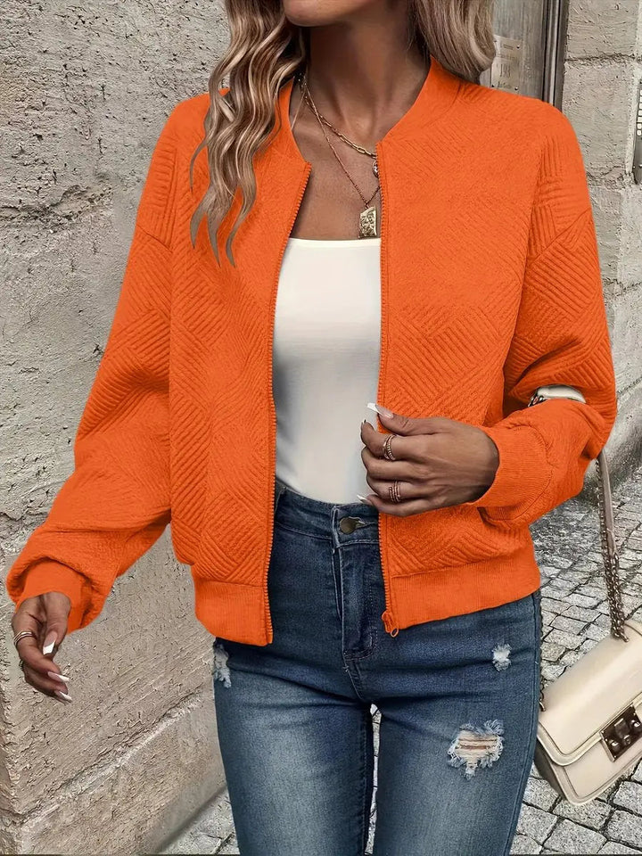 Back view of women's cropped quilted bomber jacket. Stylish textured outerwear, casual zip-up style.