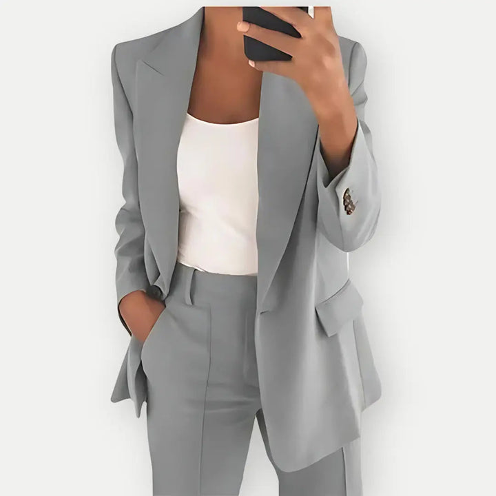 Dark blue women's tailored suit, featuring a sophisticated blazer and matching trousers.