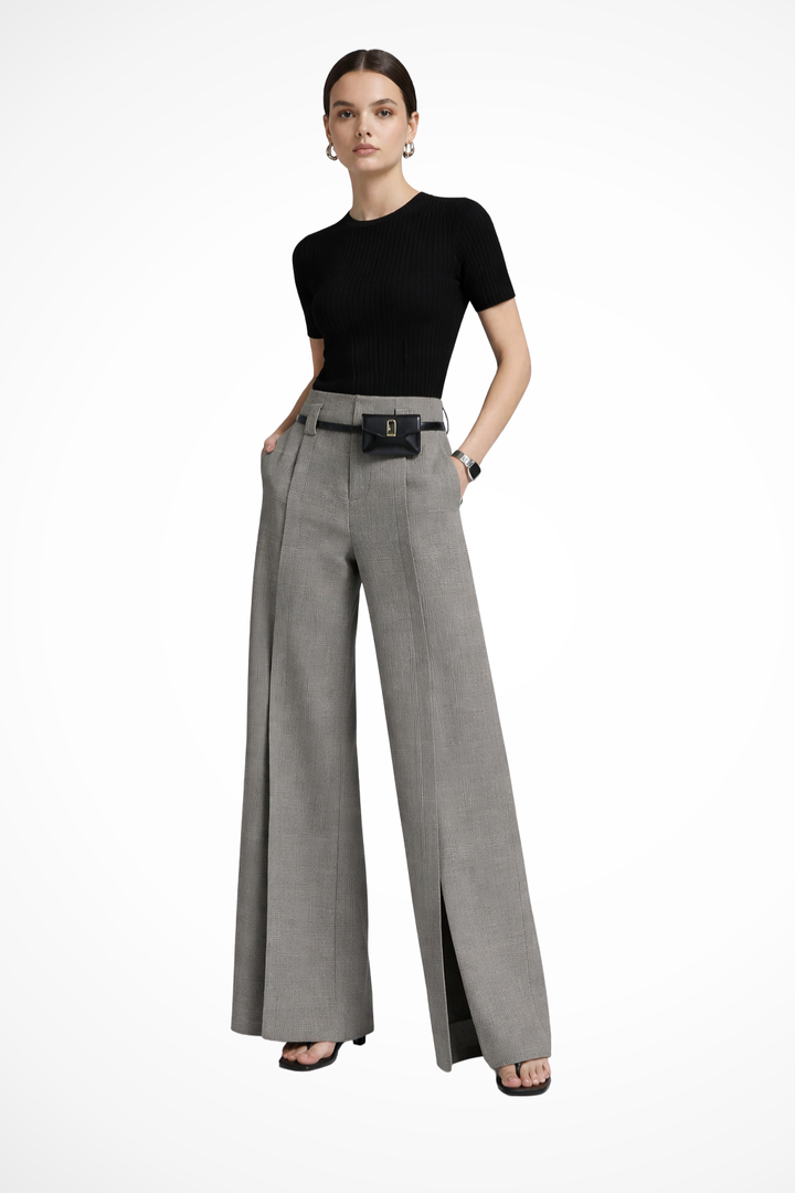 Woman modeling tailored wide leg trousers with belt detail. High-waisted fit for a sophisticated look.