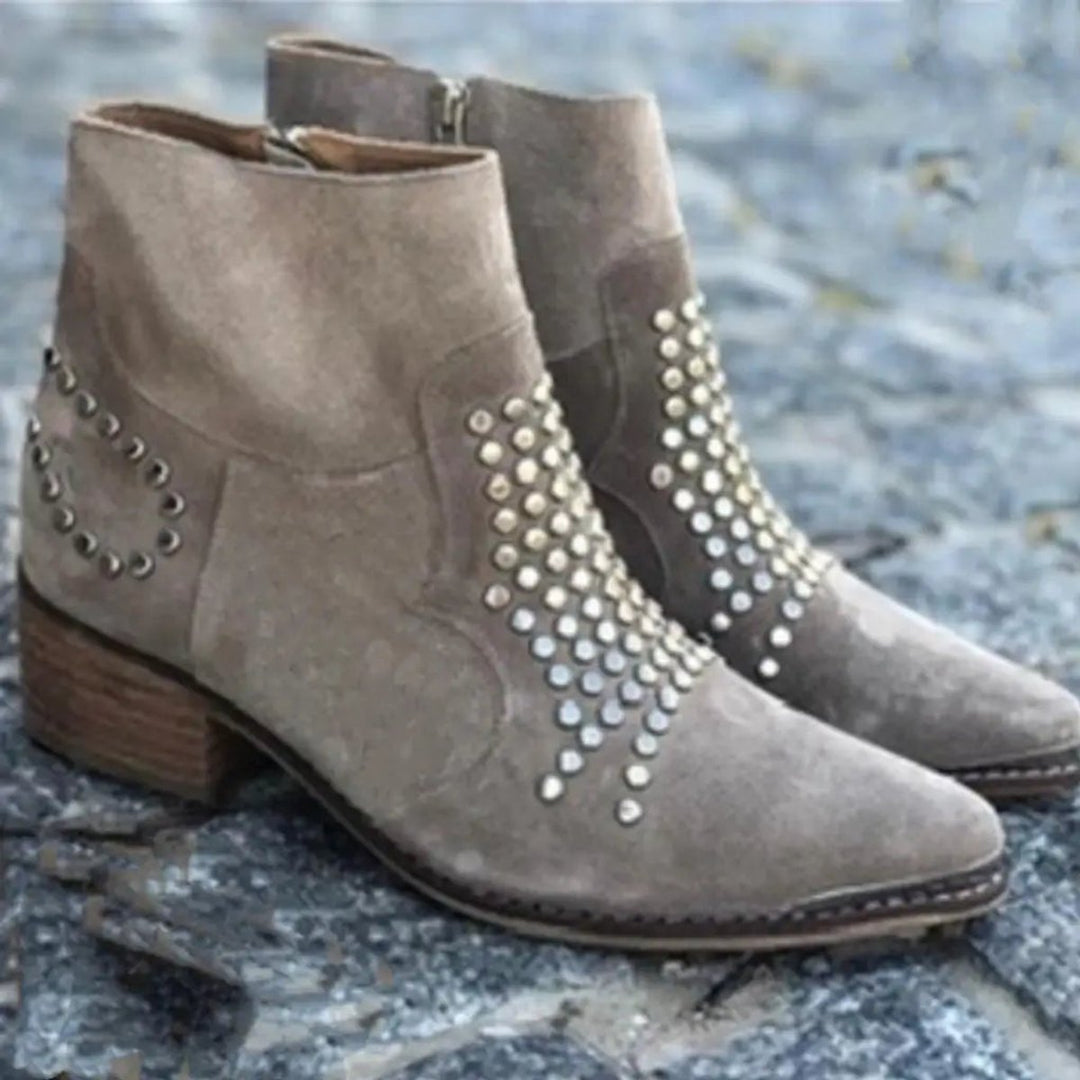 Edgy women's studded taupe ankle boots, featuring a pointed toe and sturdy block heel for a bold look.