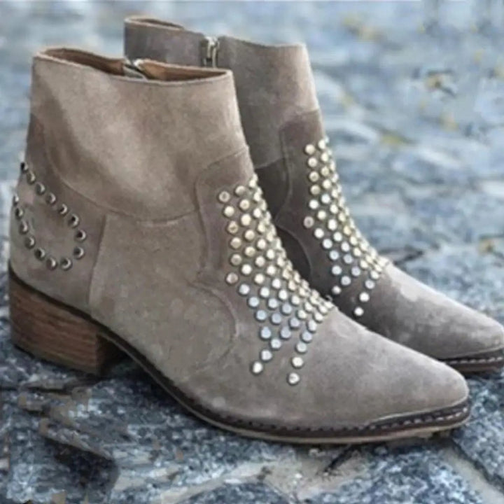 Edgy women's studded taupe ankle boots, featuring a pointed toe and sturdy block heel for a bold look.