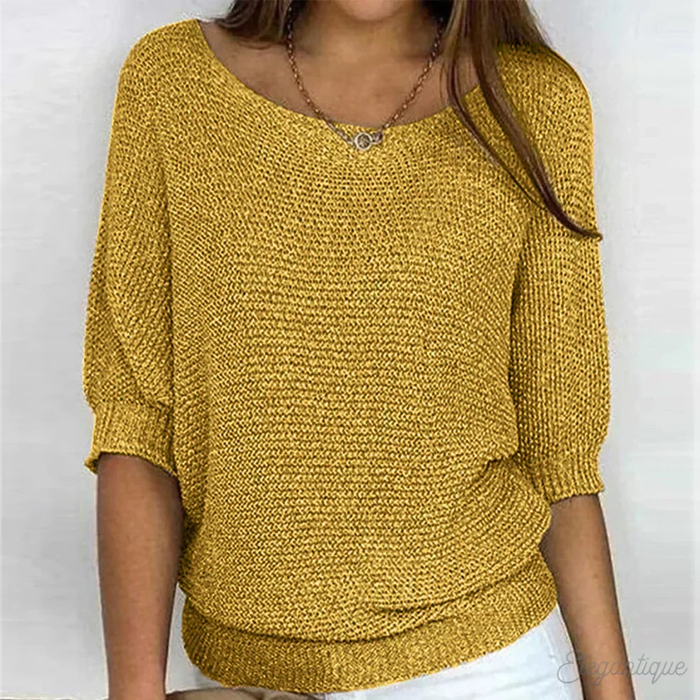Close-up of a women's textured knit top featuring a comfortable, loose batwing sleeve design.