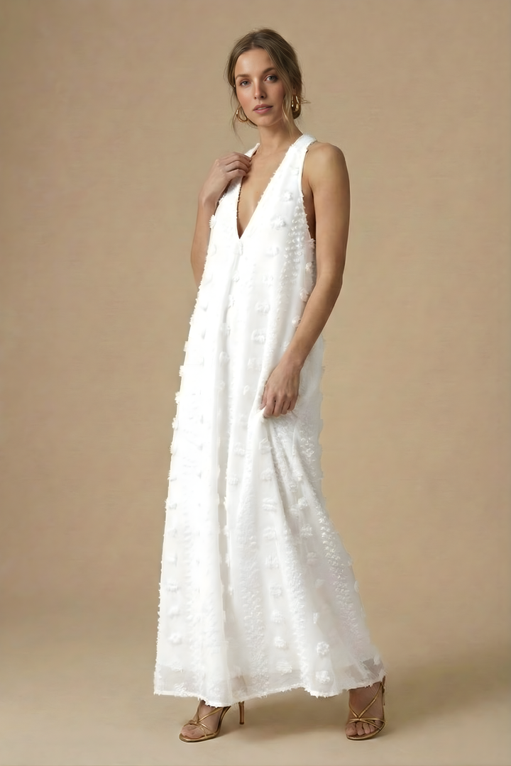 Flowing women's textured halter maxi dress with exquisite 3D floral appliqué on a backless design.