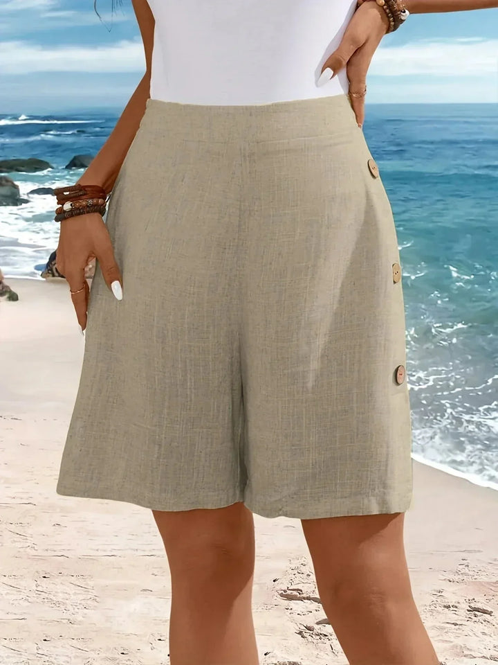 Woman in comfortable high-waisted textured wide-leg shorts with side buttons, perfect for vacation style.