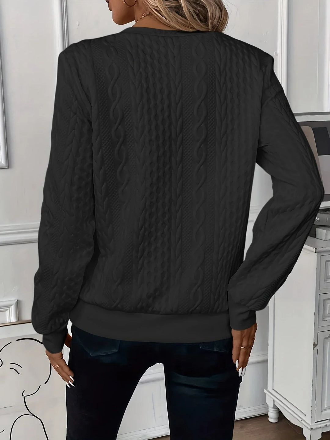 Close-up of a women's textured knit quarter-zip sweater with long sleeves, comfort wear.
