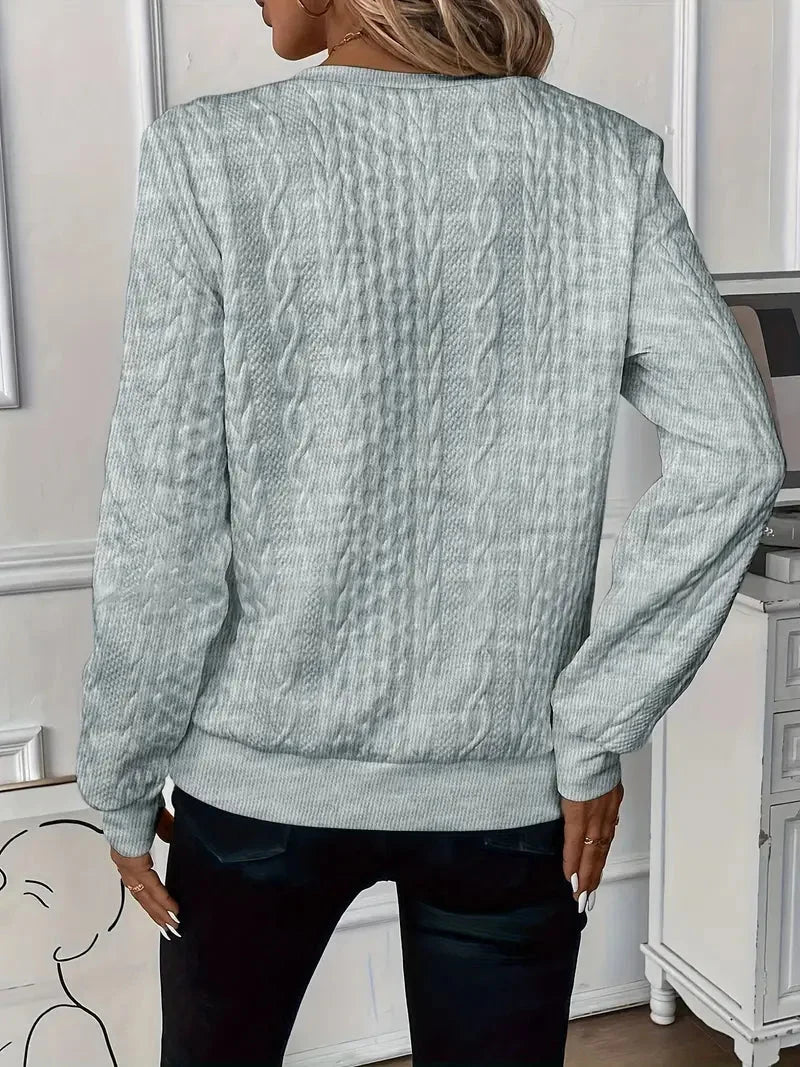 Fashionable women's quarter-zip sweater with long sleeves, textured for a chic look.