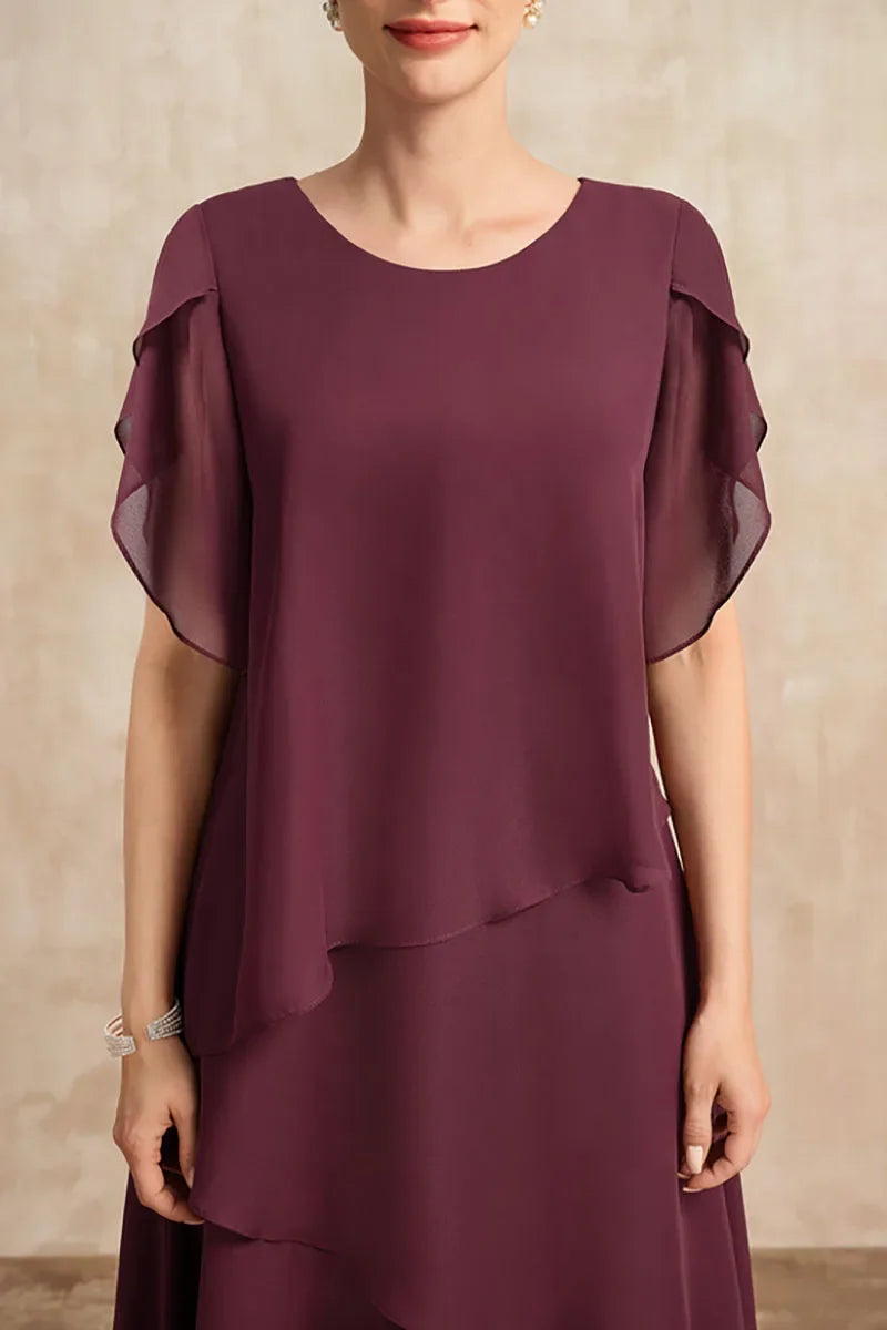 Close-up of a women's tiered midi dress, highlighting the asymmetrical layers and elegant puff sleeve detail.