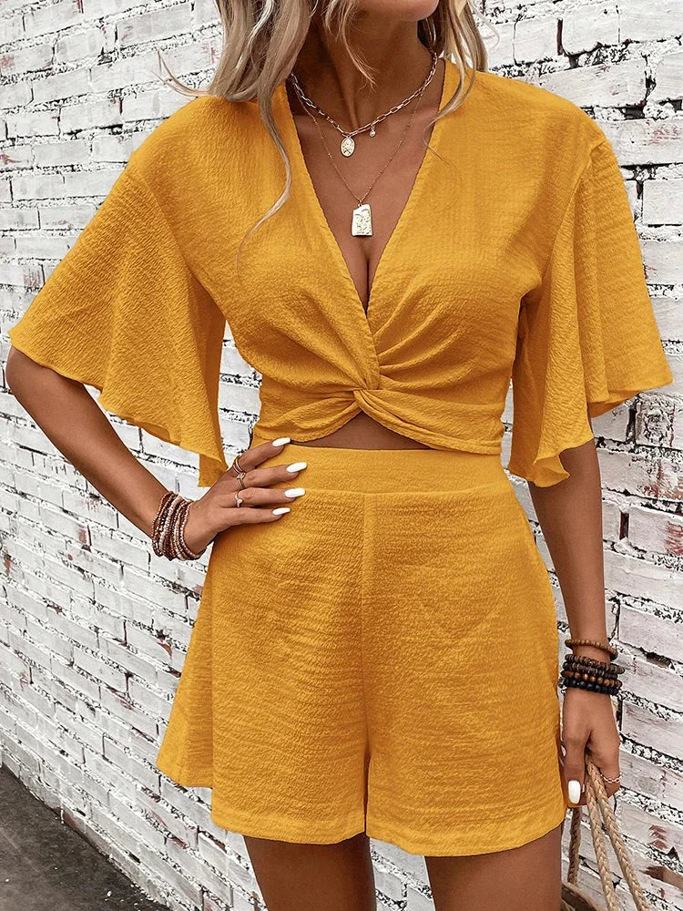 Chic women's two-piece textured flutter sleeve V-neck crop top and matching shorts, ideal for casual summer.