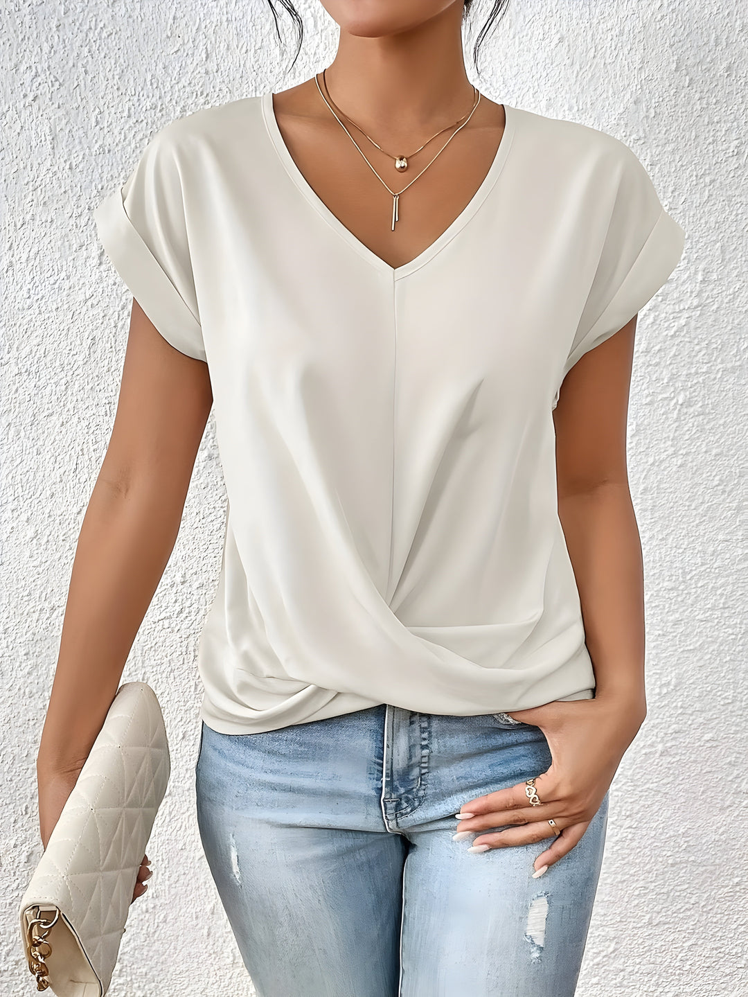 Close-up of the stylish twist front and V-neck on a women's short sleeve blouse, highlighting the unique detail.