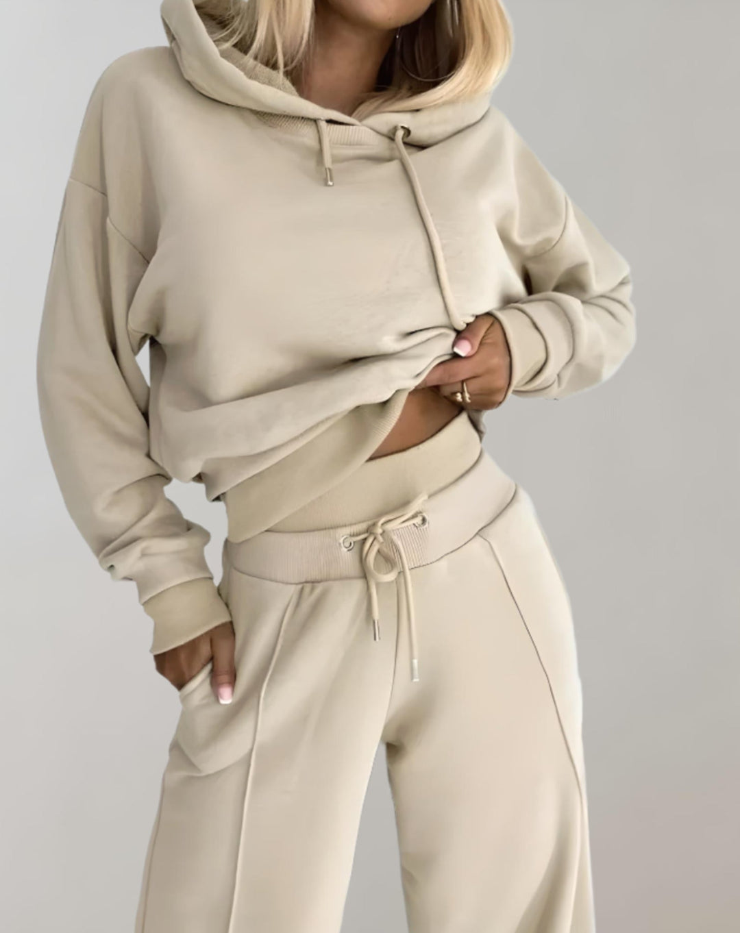 Full shot of a model wearing a chic women's two-piece hoodie & wide leg trousers set, perfect for everyday casual style.