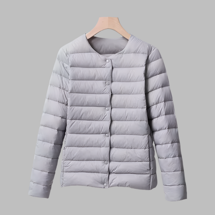 Travel-friendly women's ultralight collarless puffer jacket. Packable down outerwear for versatile layering.