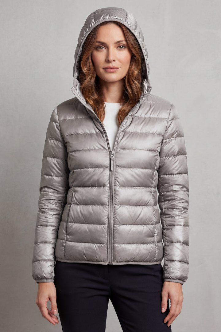 Women's travel-friendly ultralight hooded puffer, compact & warm for winter adventures.