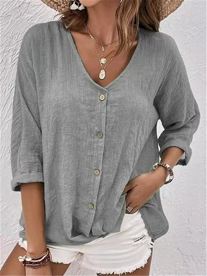 Stylish women's V-neck button-front top, crinkle texture, 3/4 sleeves. Offers a comfortable, relaxed fit.