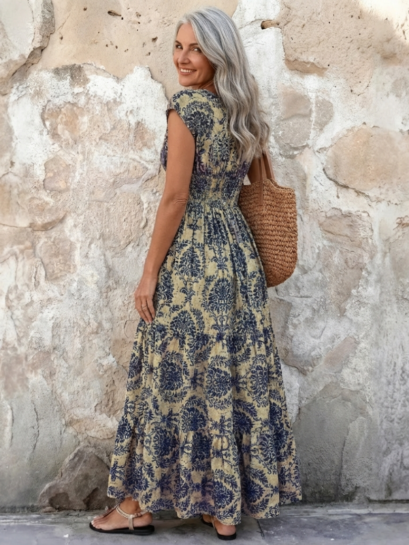 Flowing bohemian maxi dress for women, featuring a V-neck, cap sleeves, and a stylish tiered skirt.