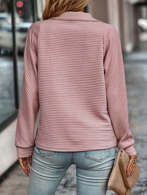 Relaxed woman wears a comfortable V-neck half-zip sweater. Versatile pullover, perfect for casual activities.