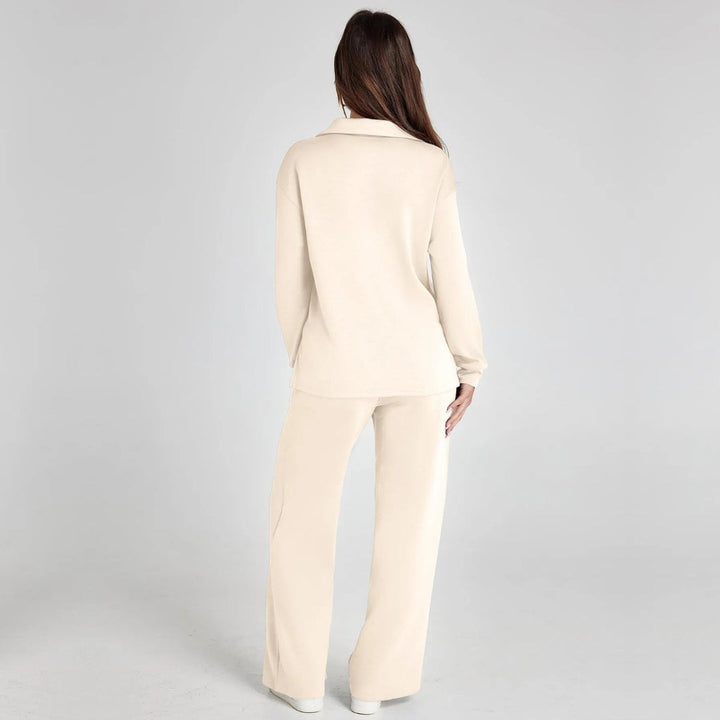 Woman sitting in a comfortable V-neck long sleeve loungewear set with stylish wide leg trousers.