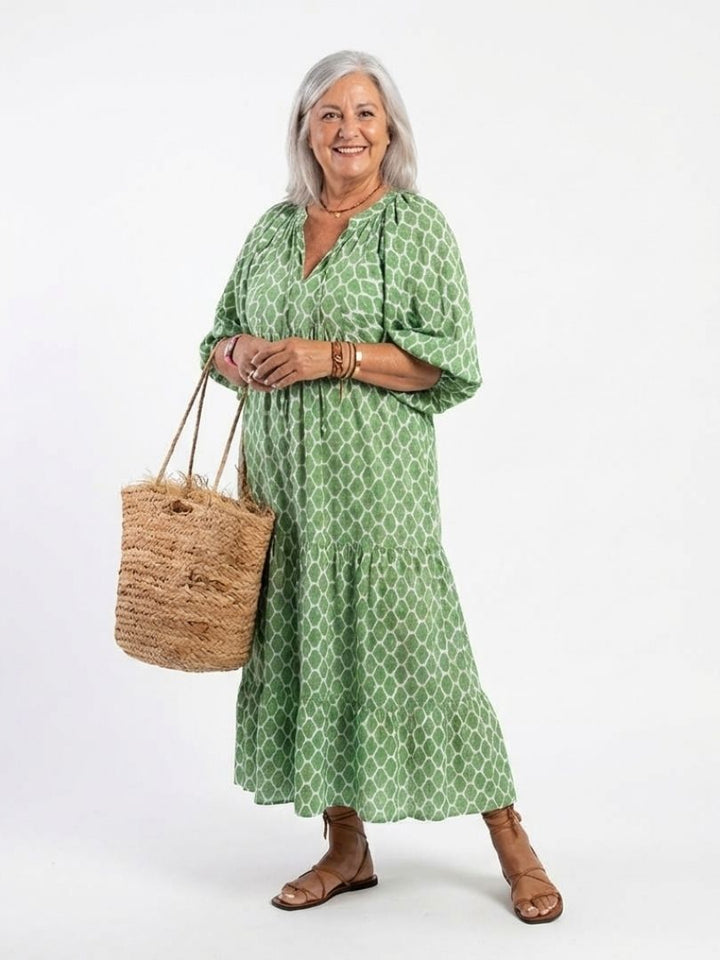Flowy tiered midi dress with a V neck and three-quarter sleeves. Stylish patterned women's casual summer dress.