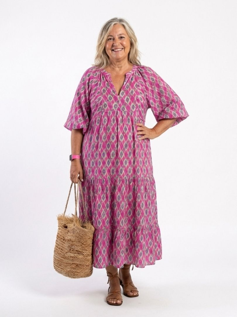 Tiered, flowy women's midi dress with a V neck and three-quarter sleeves. Vibrant patterned casual summer fashion.