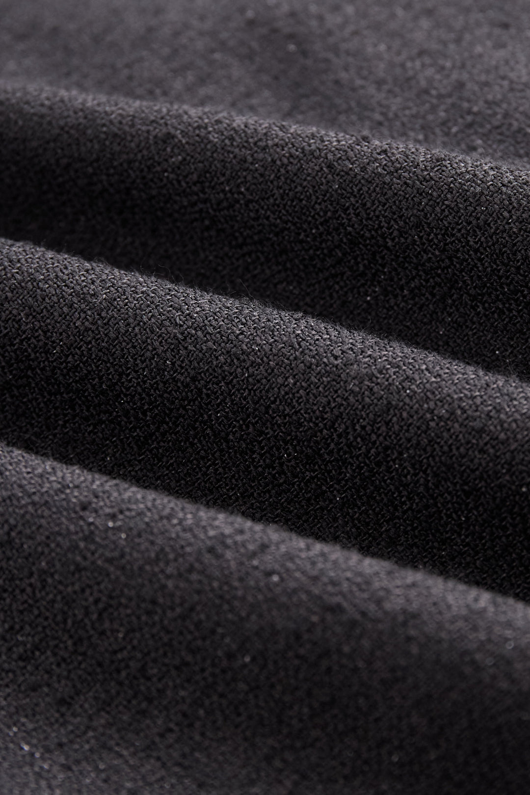 Close-up: button detail on a women's V-neck sleeveless vest, part of an elegant maxi skirt set.