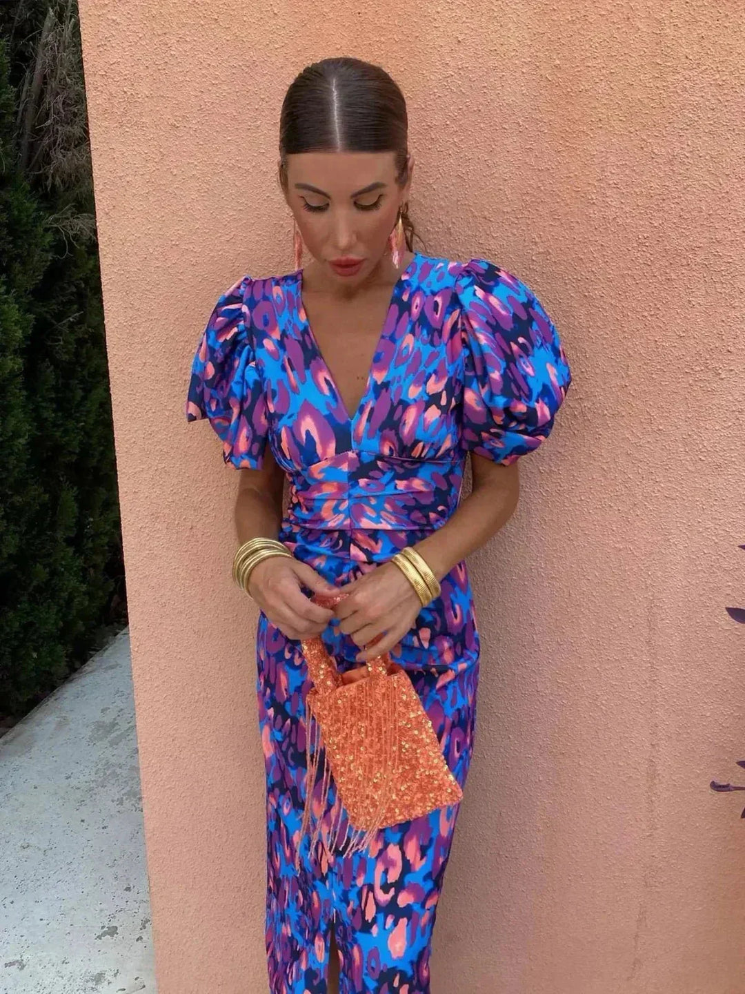 Elegant women's midi dress featuring a vibrant abstract print, V-neck, and puff sleeves, ideal for evening wear.