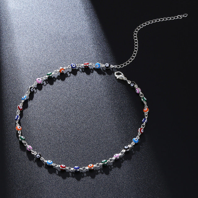 Close-up of a women's colorful beaded anklet, showcasing various vibrant beads and an adjustable chain.