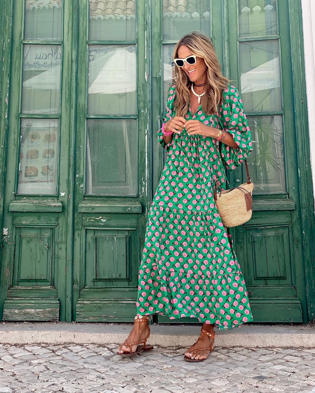 Woman relaxing in a tropical setting, wearing a stylish, printed V-neck maxi dress, ideal for resort wear.