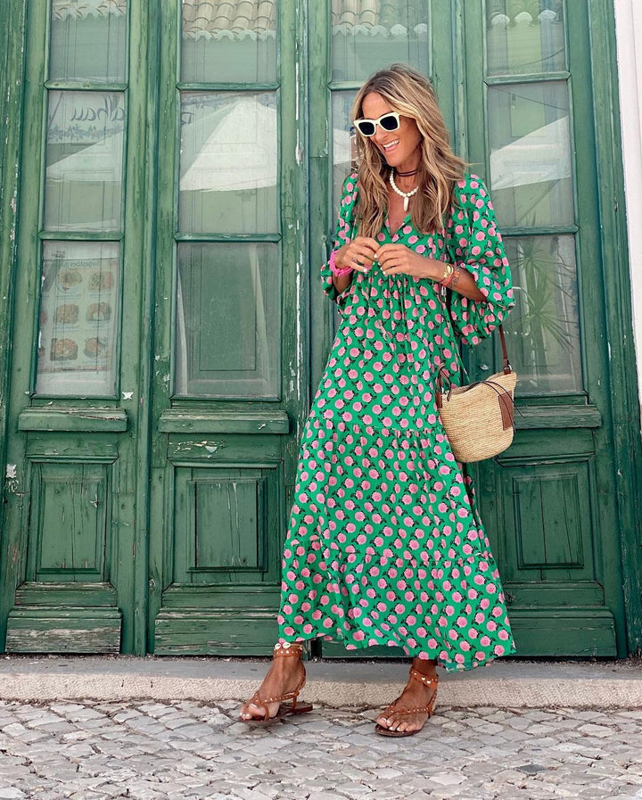 Woman relaxing in a tropical setting, wearing a stylish, printed V-neck maxi dress, ideal for resort wear.