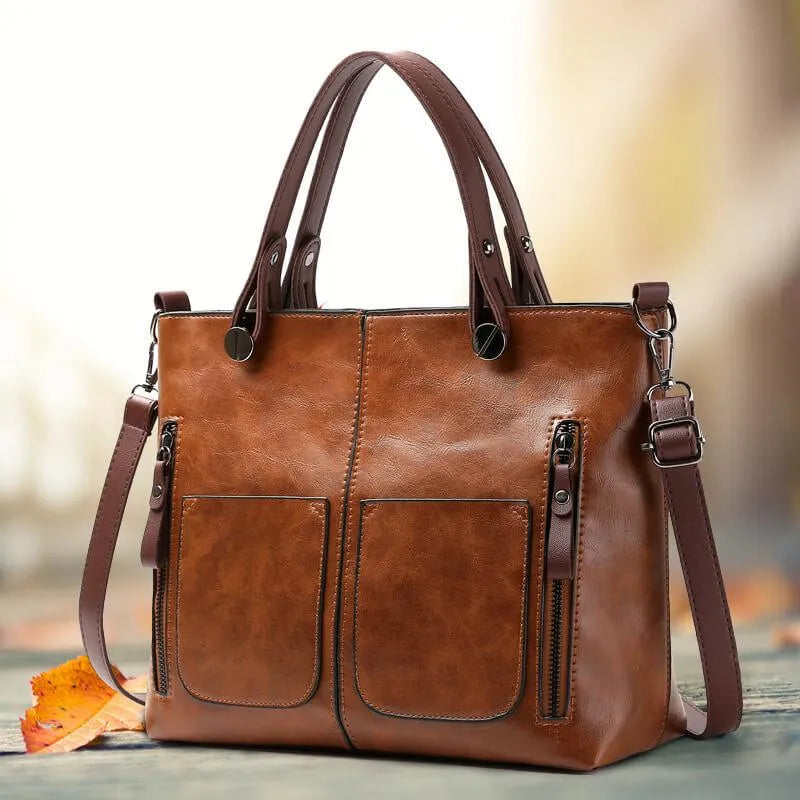 Women's vintage brown leather tote bag with multiple exterior pockets and comfortable shoulder straps.