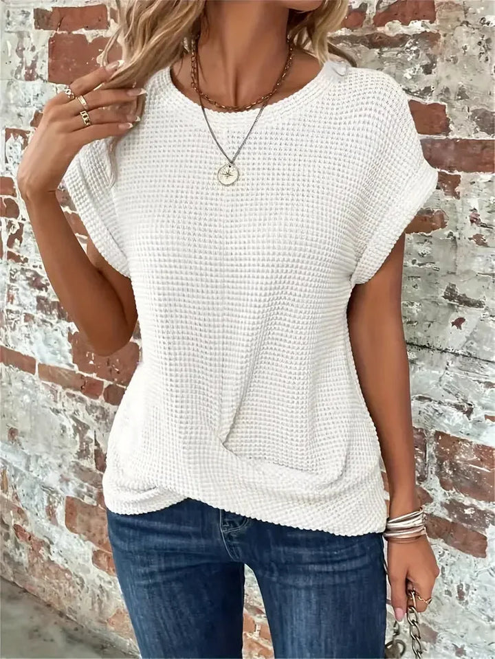 Women's waffle knit short sleeve sweater with a flattering front twist. Ideal for casual, stylish comfort.