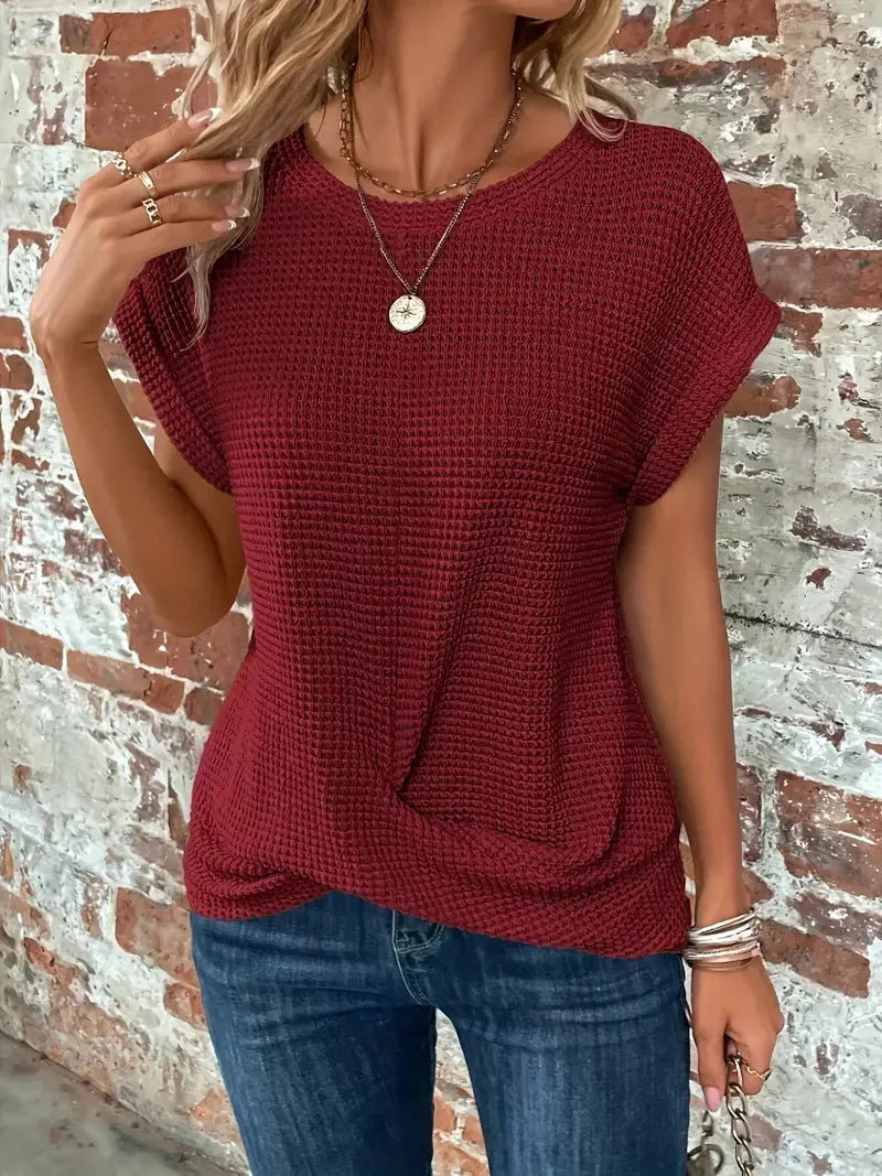 Women's fashion short sleeve waffle knit sweater with a flattering front twist. Versatile everyday top.