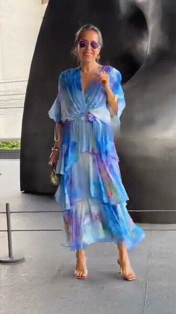 Elegant women's flowing chiffon maxi dress with tiered watercolour floral print, perfect for summer parties.