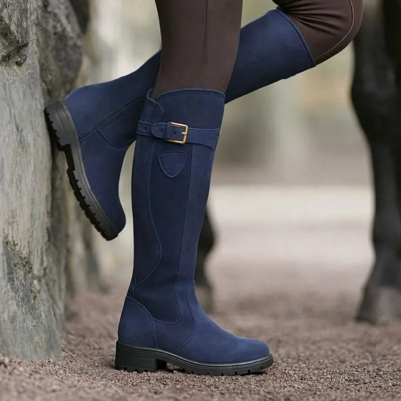 Stylish women's brown knee-high waterproof boots with a side zip, worn for a chic and practical autumn outfit.