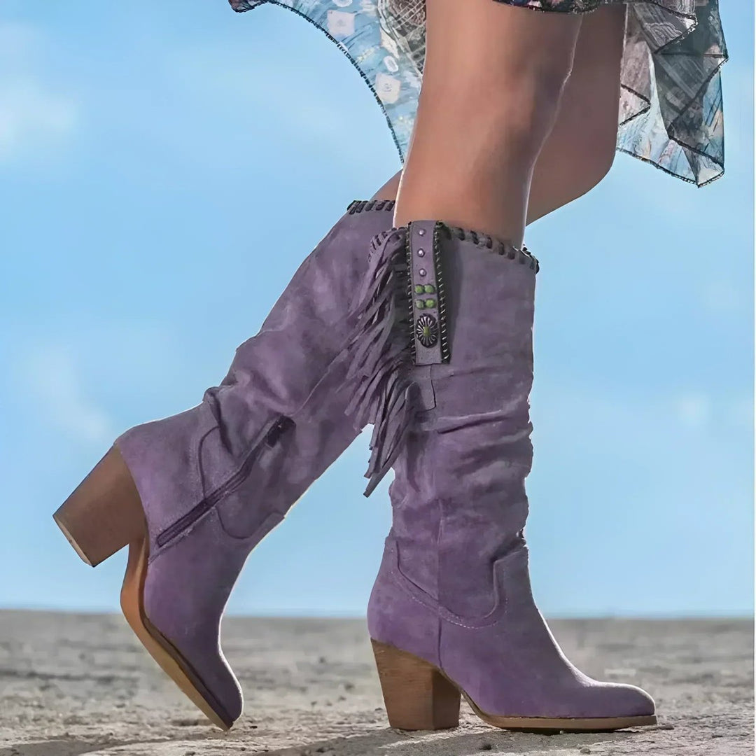 Knee-high slouchy Western boots for women, featuring intricate fringe detail & sturdy block heel, ideal for festivals.