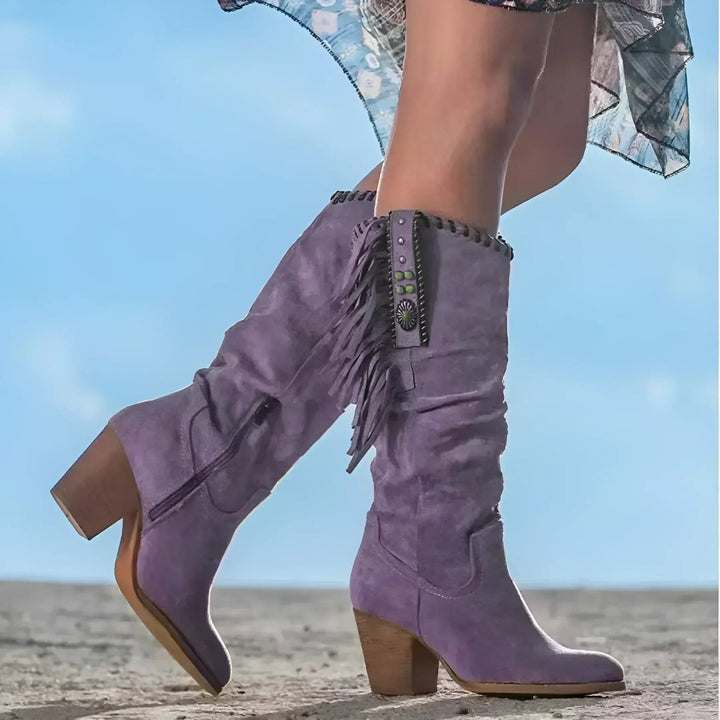 Knee-high slouchy Western boots for women, featuring intricate fringe detail & sturdy block heel, ideal for festivals.